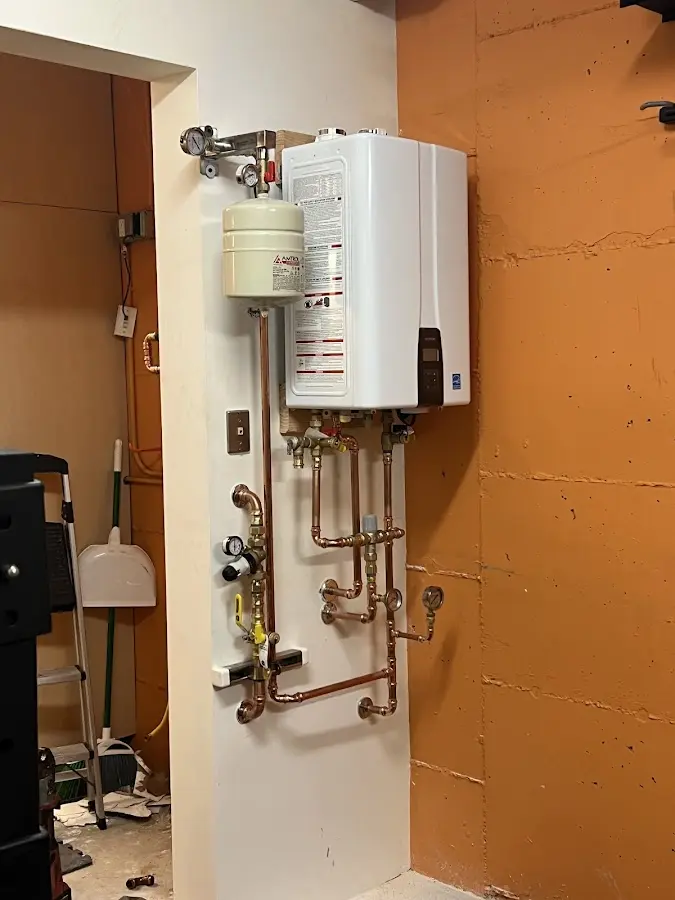 Plumbing technician inspecting water heater connections in Hainesville